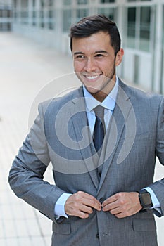 Classically good looking male buttoning up his tailored suit