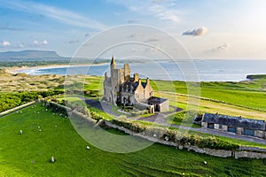 Classiebawn Castle on a backdrop of picturesque landscape of Mullaghmore Head. Spectacular sunset view with waves rolling ashore.