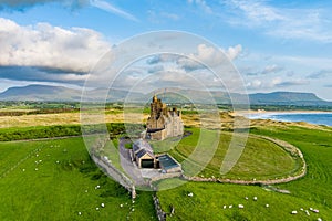 Classiebawn Castle on a backdrop of picturesque landscape of Mullaghmore Head. Spectacular sunset view with waves rolling ashore.