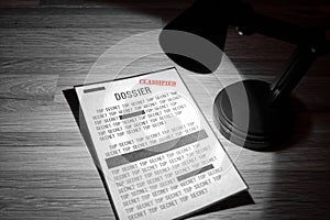Classified dossier with redactions in a spotlight