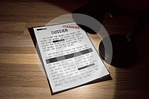 Classified and top secret dossier with redactions in a spotlight - close up