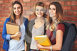 Classmates and best friends. Portrait of a group of smiling female university students standing together on campus.