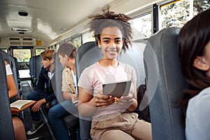 Classmates going to school by bus sitting girl close-up using app on digital tablet smiling joyful