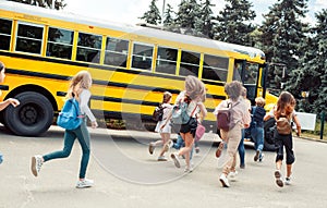 Classmates running to school bus back view late