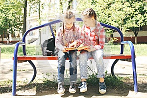 Classmates sit and read a book