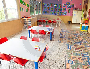 Classromm of kindergarten with tables and small red chairs