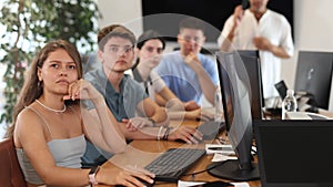 In classroom, atmosphere of intense focus prevails as teacher engages students in thought-provoking discussions.