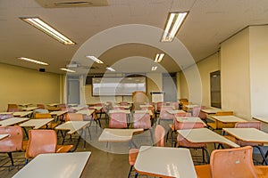 Classroom with empty desks with large whiteboard