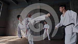 Classroom of original martial taekwondo craft. Warriors in national kimono shows powerful and strong kick while jumping