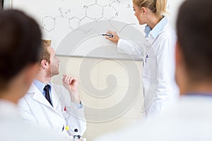 In the classroom student write chemical formula at the blackboard