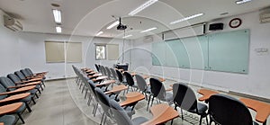 Classrooms for students in campus buildings with chairs and glass boards that use projectors for learning and teaching.