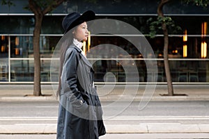 Classy asian woman walking in the city with hat