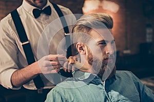 Classy dressed barber shop hairdresser is cleaning client`s neck