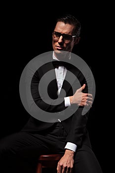 Classy man in black wearing glasses posing in dark studio