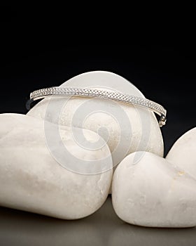 Classy silver bracelet silvery jewellery close-up on top of white stones