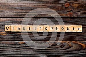Claustrophobia word written on wood block. claustrophobia text on table, concept