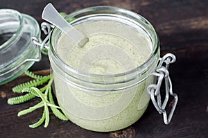 Clay and algae mask in a glass jar. Diy face or hair mask and body wrap recipe. Natural beauty treatment and spa.