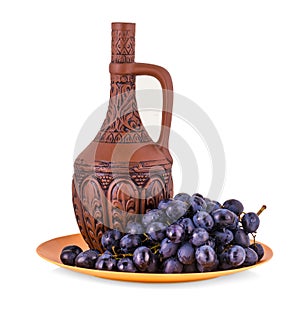 Clay bottle and grapes on a white background.