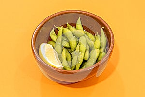 Clay bowl with edamame pods with flaked salt