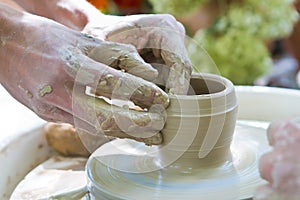 Clay bowl making lesson, hands make a clay bowl on a pottery wheel