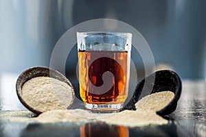 Clay bowl on wooden surface full of Poppy seeds or khus or opium poppy or breadseed poppy with its extracted herbal and organic pl