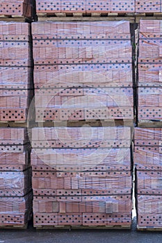 Clay brick's pallet at the storage yard. pallets with bricks in the building store. Racks with brick. Masonry, stonework.