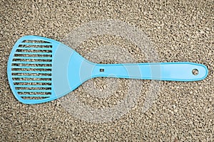 Clay cat litter with plastic scoop, top view