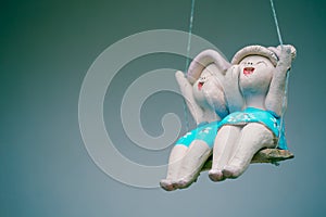Clay child dolls sitting on swings in home, Concept of decoration and garden arrangement.