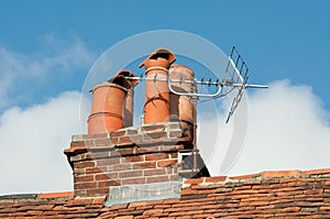 Clay chimney pots on old tiled roof