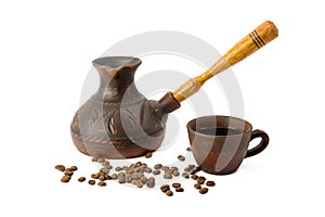 Clay coffeepot, cup with black coffee and roasted coffee beans isolated on white