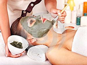 Clay facial mask in beauty spa.