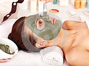 Clay facial mask in beauty spa.