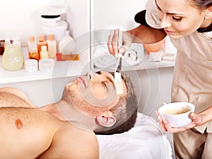 Clay facial mask in beauty spa.