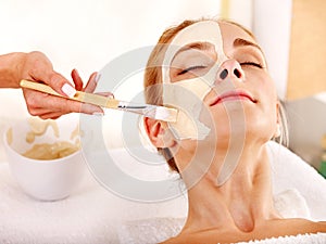 Clay facial mask in beauty spa.