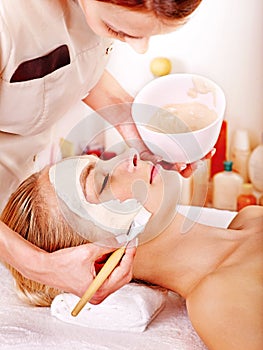 Clay facial mask in beauty spa.