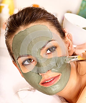 Clay facial mask in beauty spa.