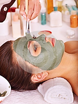 Clay facial mask in beauty spa.