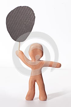 clay figure holding empty blank protest banner