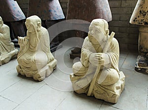 Clay figures of Buddhist monks, peacefully sitting in a lotus po