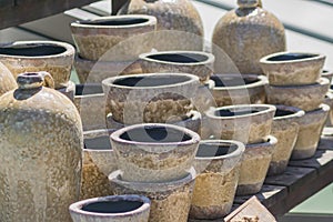 Clay flower pots and vases stucked on wooden table in the garden