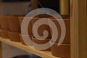 Clay flowerpots in a row on the shelf