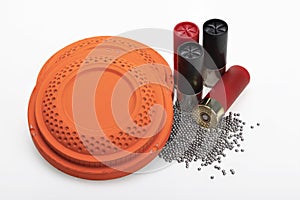 Clay flying target and Shotgun shell ammunition with lead pellets on white background , gun and shooting game