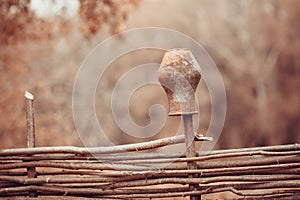 Clay jug on a wicker fence