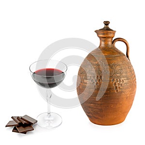 Clay jug for wine,glass of red wine and chocolate isolated on white . Collage