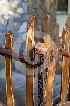 Clay jug on wooden fence. Rural scenery. Traditional old Slovenian Ukrainian clay pots on a wattled fence. Wicker fence