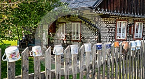 Clay jugs on fence in front of old wooden house in village Cicmany