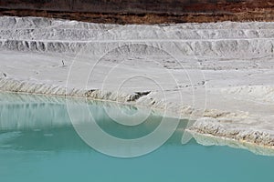 Clay mining. Beautiful background of white clay. Blue water.