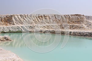 Clay mining. Beautiful background of white clay. Blue water.