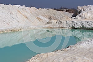 Clay mining. Beautiful background of white clay. Blue water.