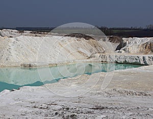 Clay mining. Beautiful background of white clay. Blue water.